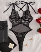 Black lace lingerie bodysuit with tie shoulder bows and underbust hook closure detail