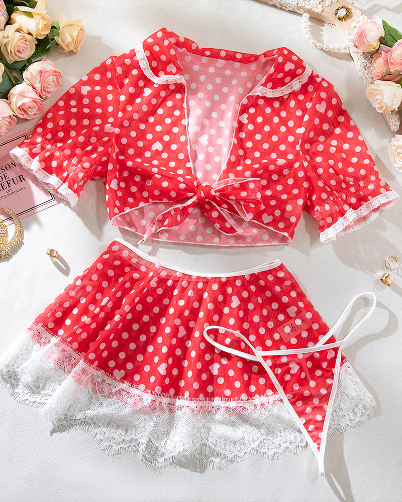 Red polka dot lace-trim lingerie set laid out: bow crop top and mini skirt