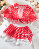 Red polka dot lace-trim lingerie set laid out: bow crop top and mini skirt