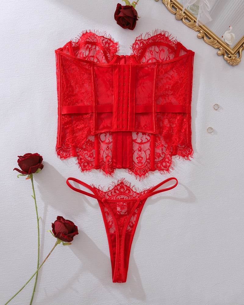 Red lace corset top with front panels and matching lace thong, flat lay