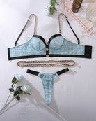 Blue plaid lingerie set flat lay: bra top, thong, black straps, gold-tone waist chain