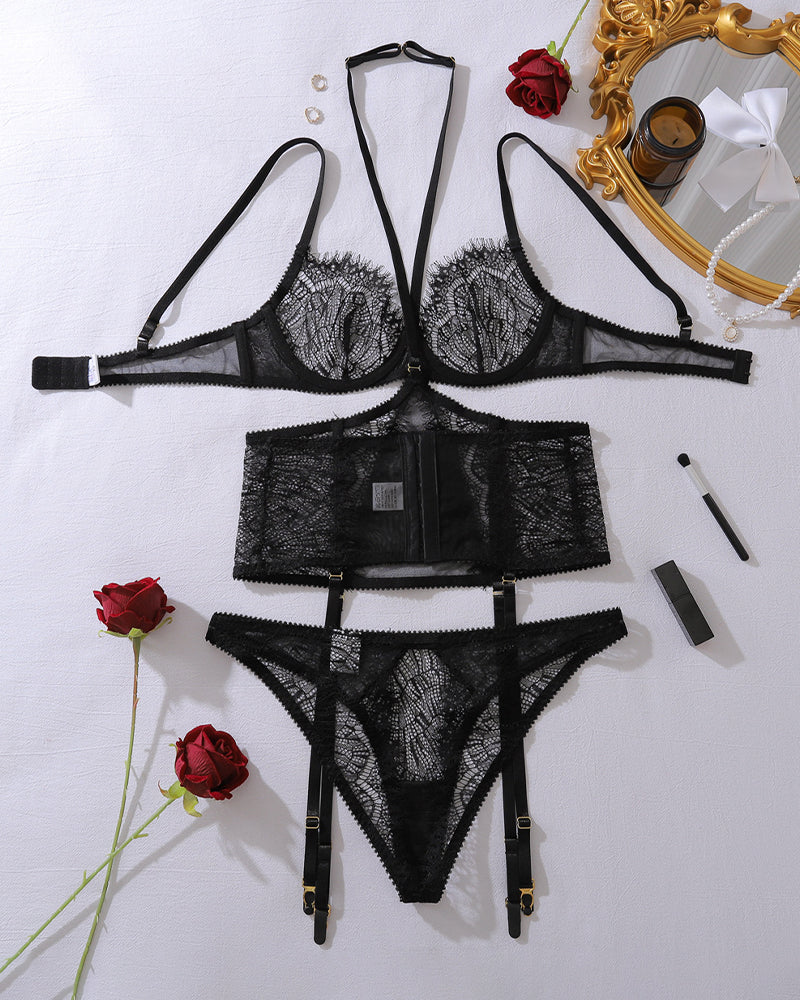 Black lace lingerie set flat lay with underwire bra, thong, garter belt pieces