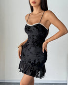 Black velvet mini dress with ruched bodice, lace-trimmed sweetheart bust and ruffled hem