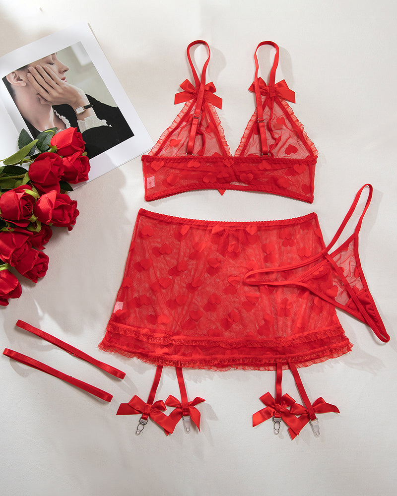 Red heart mesh bra and mini skirt set laid flat with bow ties and garters