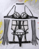 Black mesh lingerie set flat lay: cage bra, corset belt, thong, and gloves