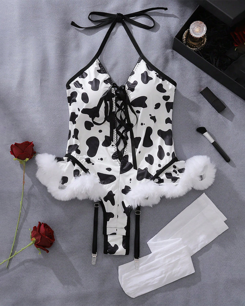 Cow print lace-up halter bodysuit with faux-fur cuffs and garter straps, laid flat