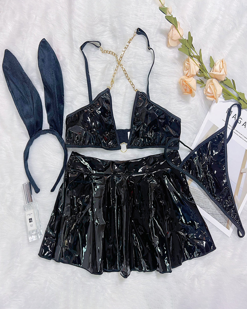 Black PU leather chain bra and mini skirt set with rabbit-ear headband, flat lay