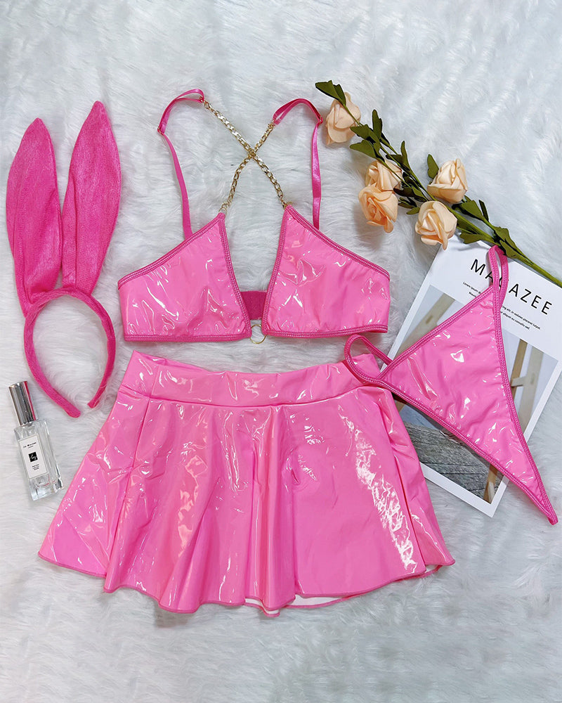 Pink PU leather chain bra and mini skirt set with rabbit-ear headband, flat lay