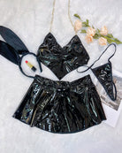 Black heart halter bra and flared mini skirt set with bunny ear headband, flat lay