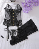 Black lace-up corset bra set with stockings and lace panties, laid flat