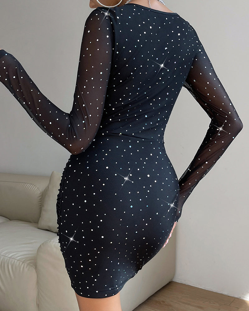 Black fitted dress with sheer long sleeves and scattered star-dot sparkle all over
