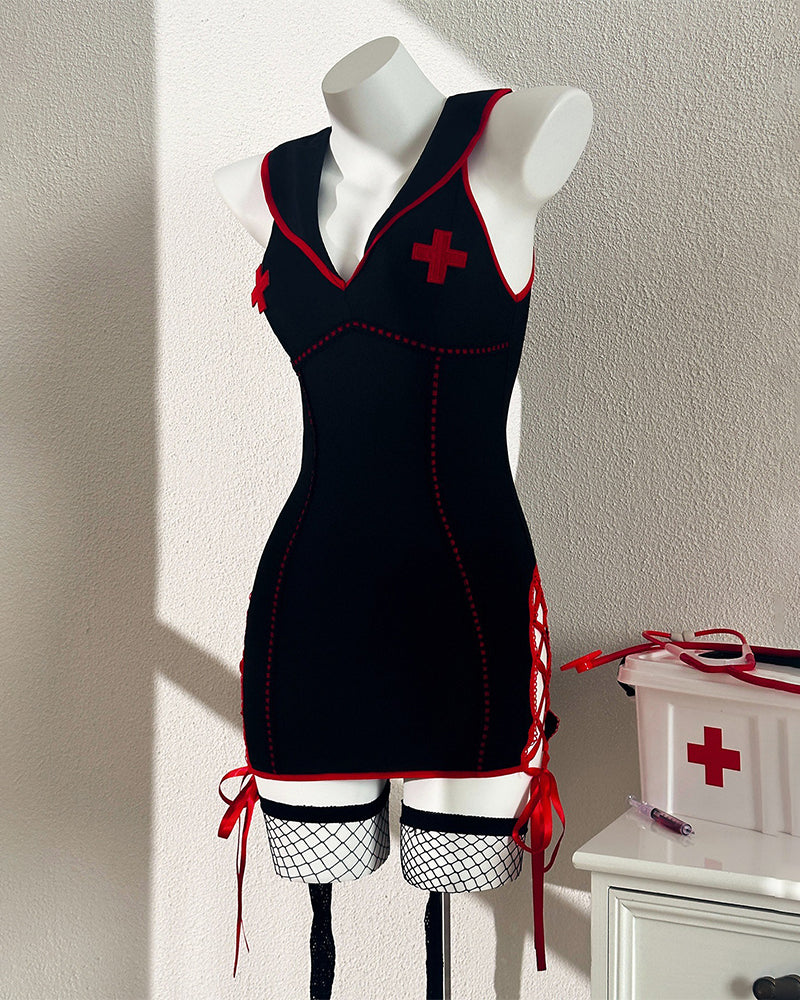 Black nurse chemise dress on mannequin with red trim, cross details, and stockings