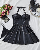 Black leather halter mini dress set flat lay with buckled straps, chain belt, flared skirt