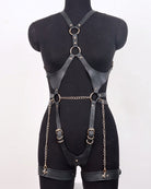 Black faux leather full-body harness with crossed shoulder straps and chain waist ties