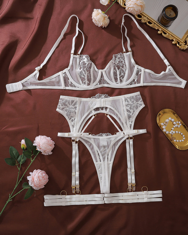White lace lingerie set flat lay with underwire bra, garter belt, and high-cut panties