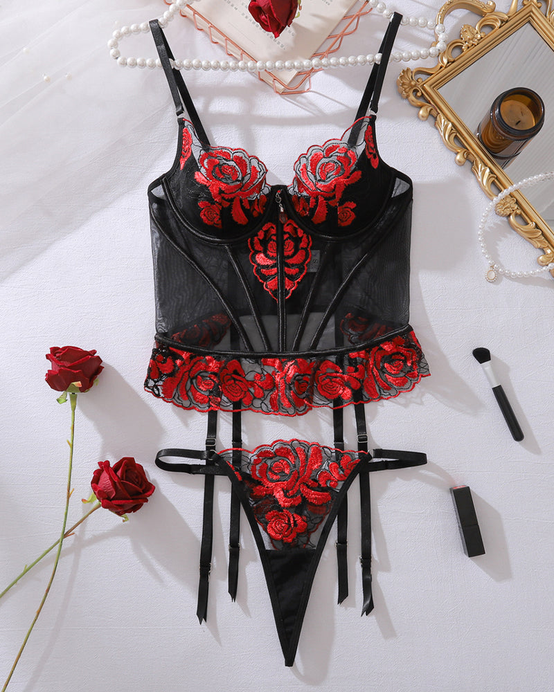 Red rose embroidered lace corset lingerie set laid flat with garter straps and thong bottom