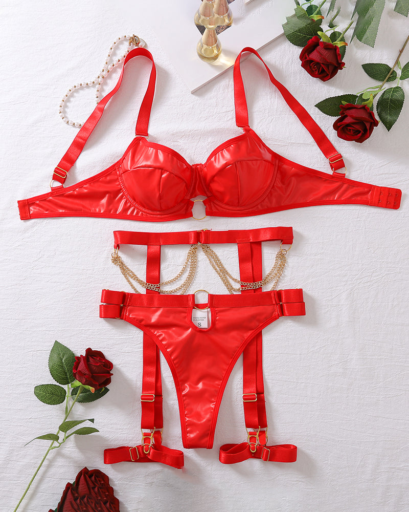 Red harness lingerie set laid out: bra, garter belt, thong, thigh straps