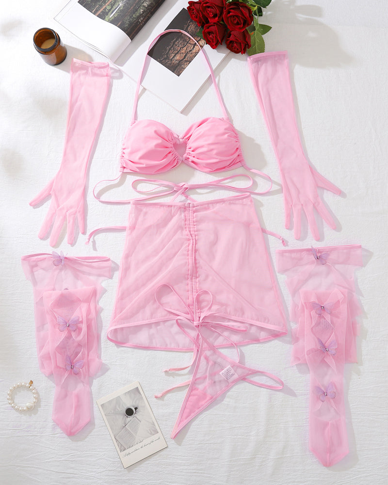 Pink sheer mesh lingerie set flat lay: bra, mini skirt, long gloves, garter stockings