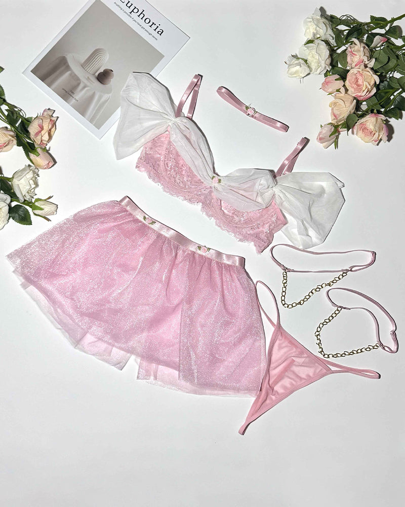 Pink tulle lingerie set flat lay with off-shoulder bra, skirt, and garter straps