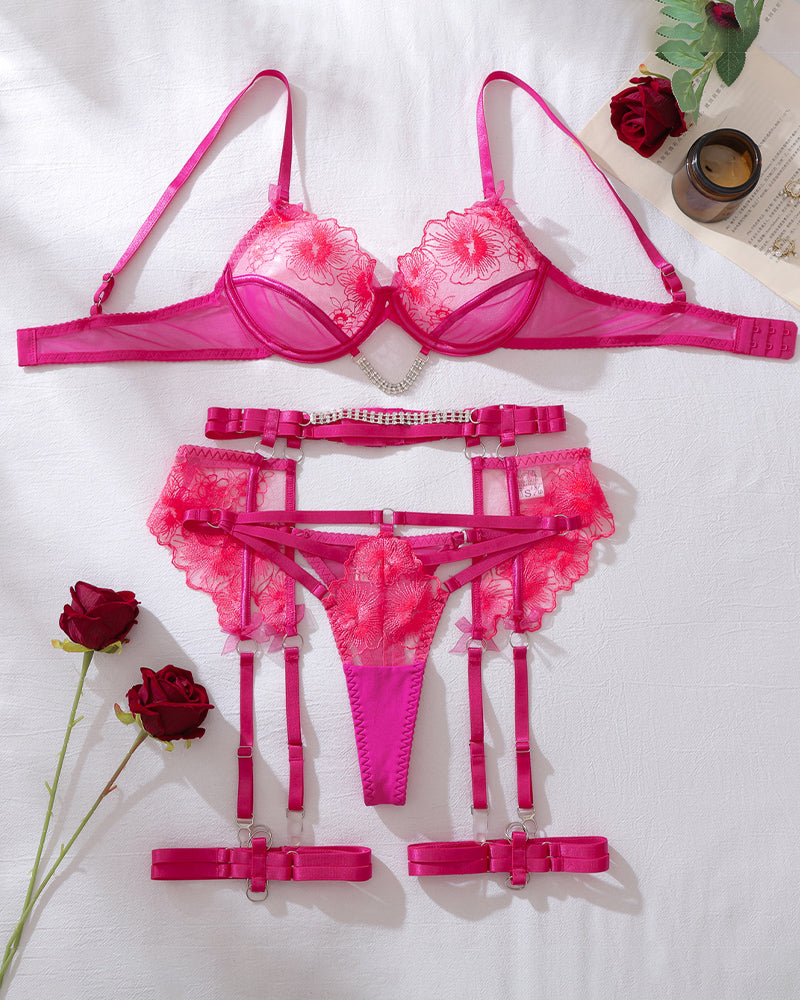 Hot pink floral lace lingerie set laid flat: bra, thong, garters, and straps