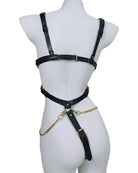 Black leather harness bodysuit back view, wide straps, gold chain hip connector