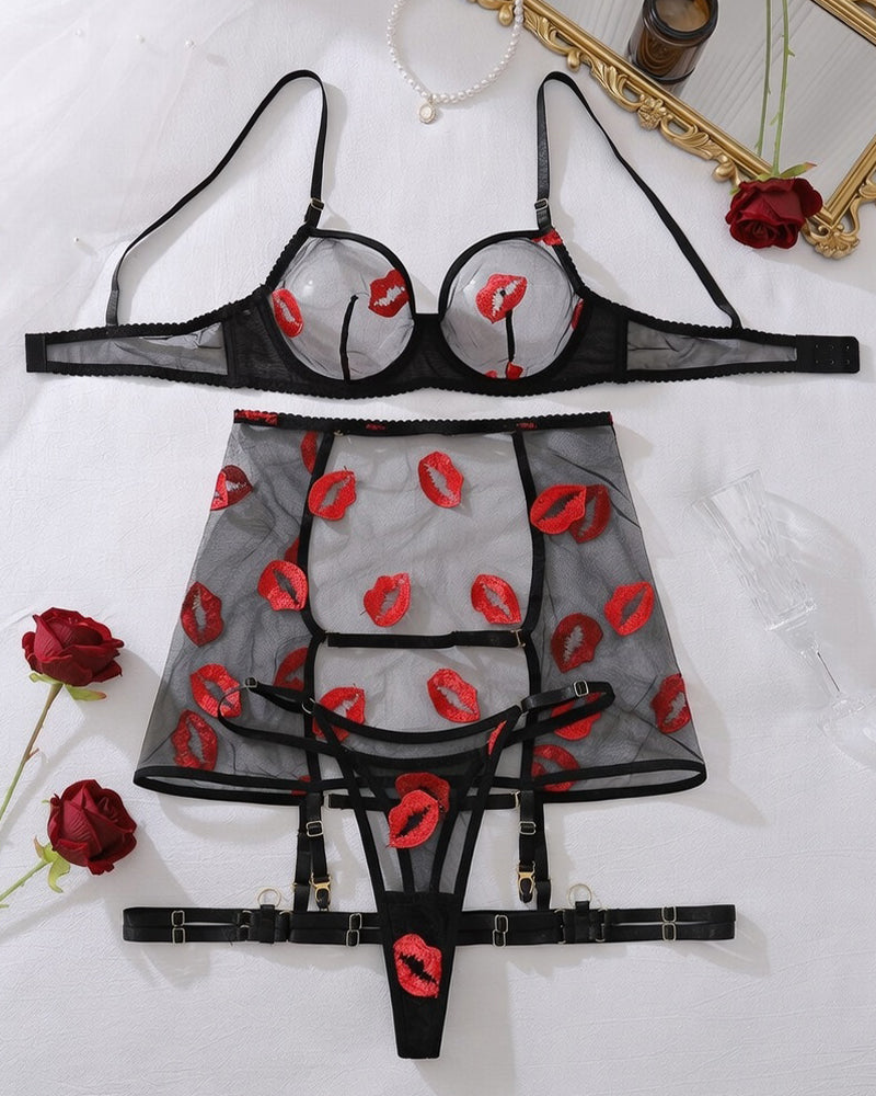 Black lingerie set with red lip print, sheer bra, matching garter skirt and thong