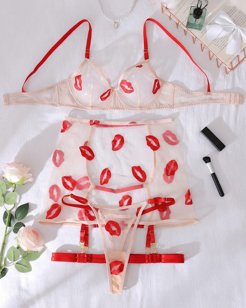 White lingerie set with red lip print, sheer bra, matching garter skirt, and thong