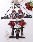 Black and red floral lace lingerie set laid flat: bra, garters, thong, and choker.