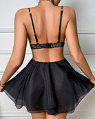 Back view of black sheer mesh babydoll lingerie with lace bra and ruffled skirt