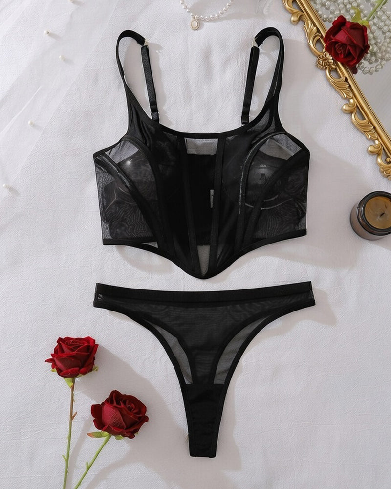 Black sheer mesh cut-out bodysuit top and thong-style bottom, flat lay