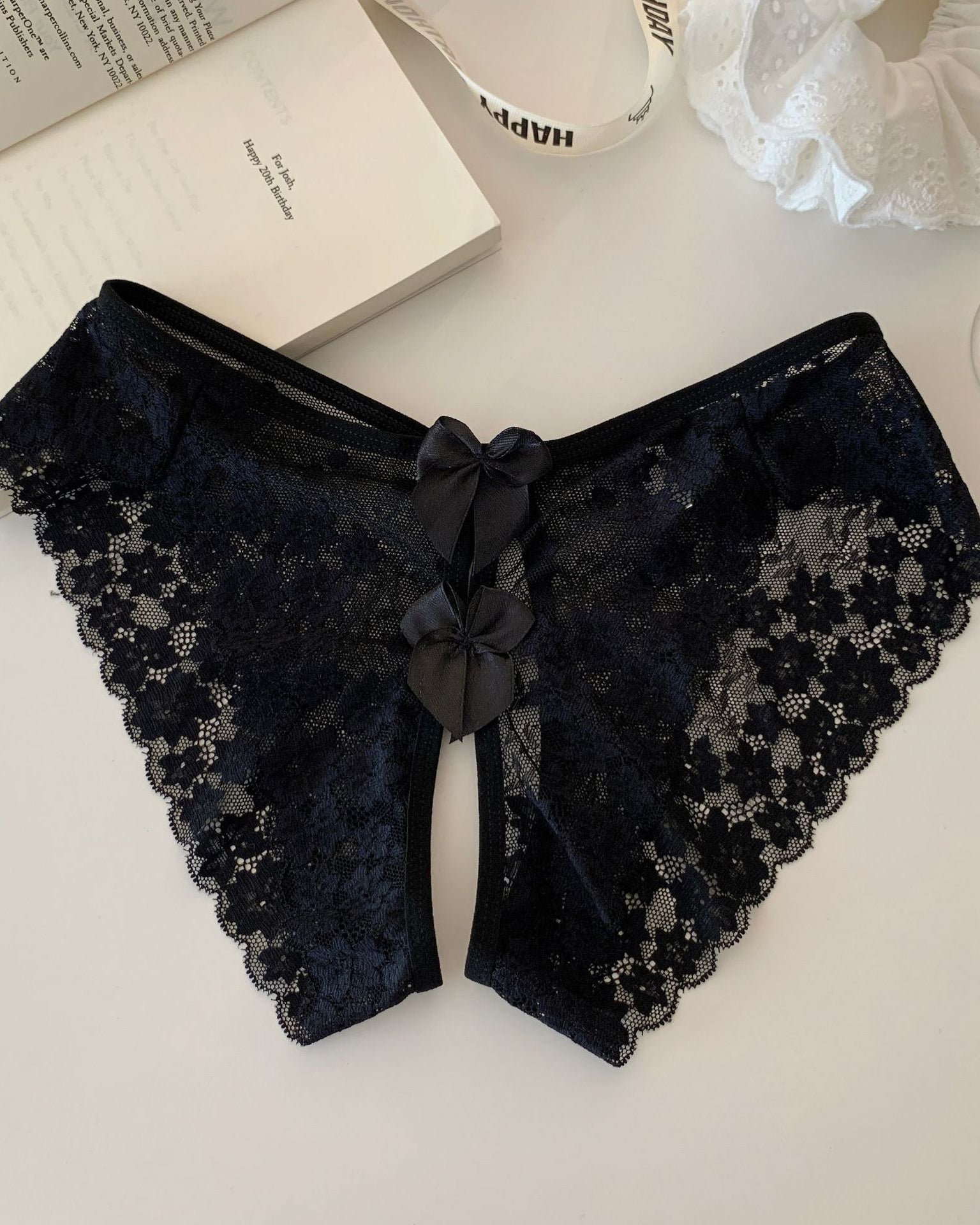 Scalloped sheer lace bow-back panties in black with central bow detail