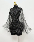 Black rhinestone mesh cape top on mannequin with long sleeves and allover studs