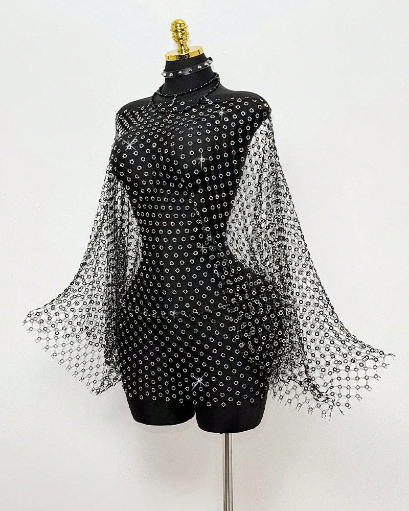 Black rhinestone mesh cape top on mannequin with long sleeves and allover studs