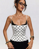 White polka dot bustier-style crop top with black lace-trim neckline and spaghetti straps