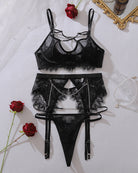 Black sheer mesh lingerie set flat lay: bra top, lace garter thong, chain accents