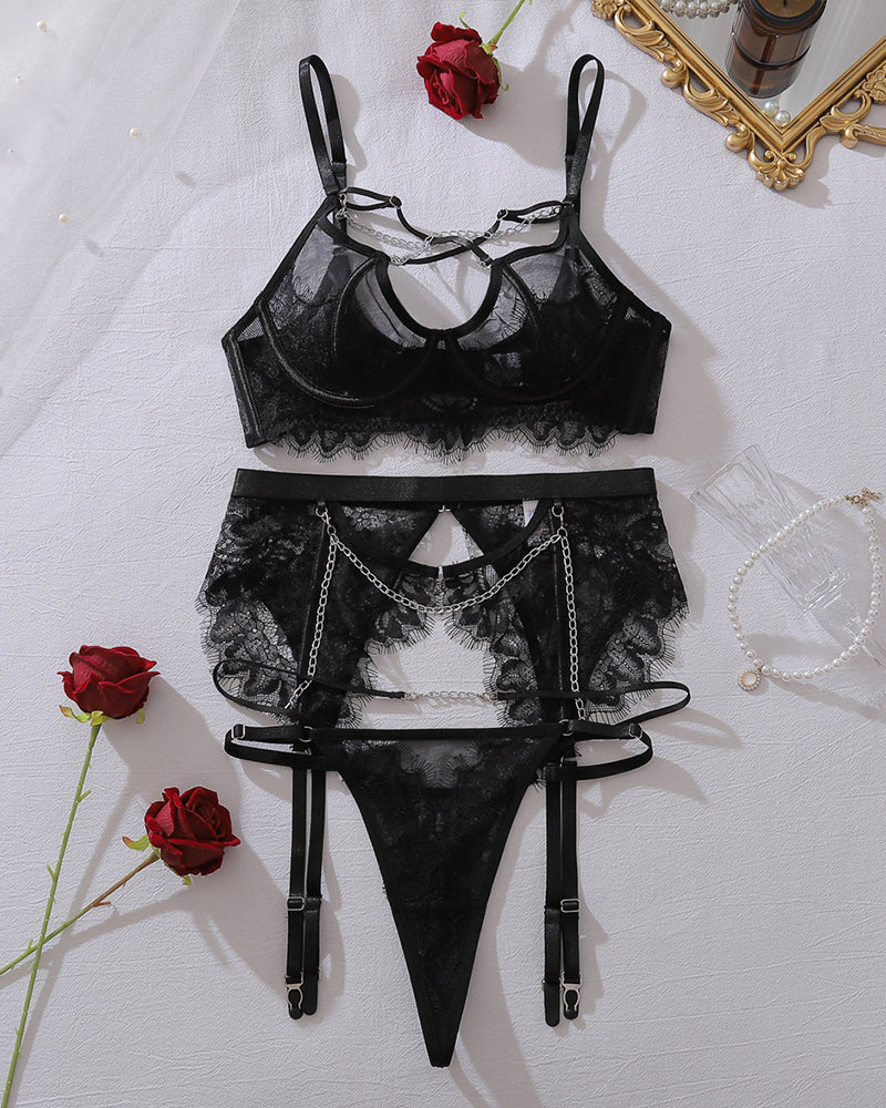 Black sheer mesh lingerie set flat lay: bra top, lace garter thong, chain accents