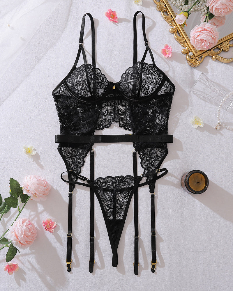 Black lace lingerie set with underwire bra, thong, and garter belt straps, flat lay