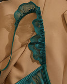 Teal lace cupless lingerie piece with scalloped edging and tie strap detail
