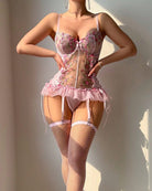 Pink floral lingerie corset with lace garter straps, ruffled tulle hem, and fishnet tights