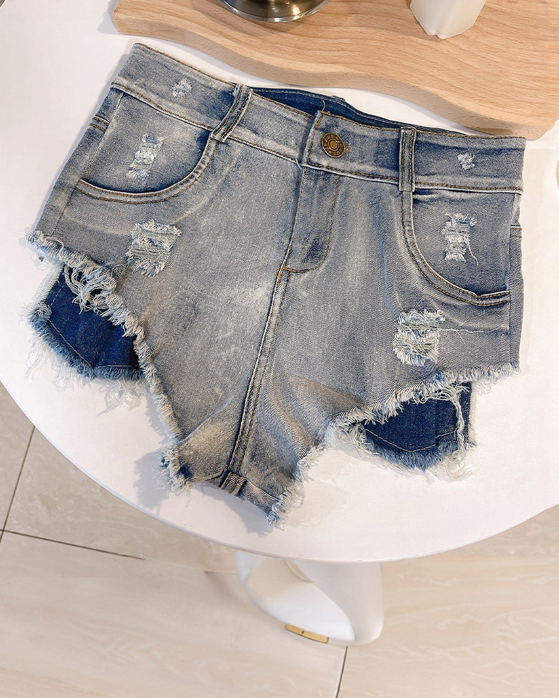 Blue high-waisted ripped denim shorts lying flat with frayed edges and patch pockets
