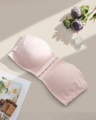 Light pink strapless bandeau bra with front hook closure, flat lay