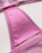 Pink sheer mesh thong close-up with decorative stitch trim and rhinestone heart.