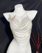 Pearl halter top on mannequin with butterfly ornament, layered beads and dangling chains