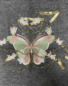 Embroidered butterfly bodice with teal-and-pink wings and gold chain trim