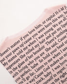 Sheer pink mesh with black lyric text print, close-up of lettering