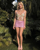Embroidered butterfly top with pearl choker and pink sequin mini skirt