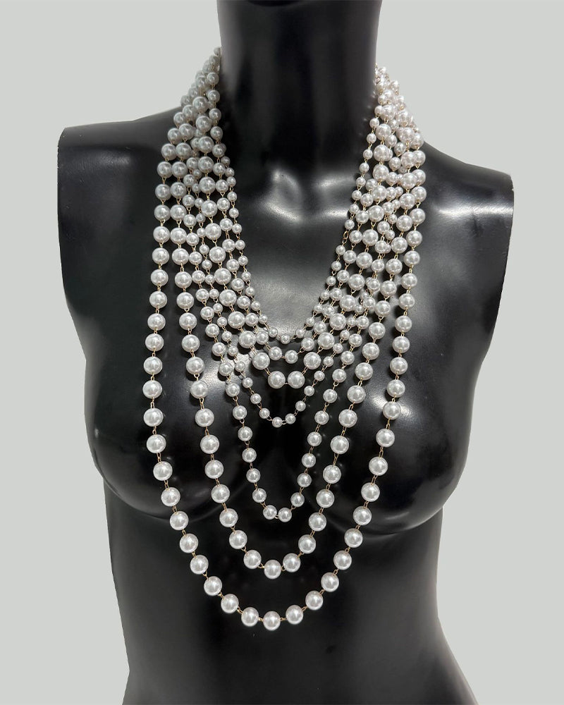 Pearl body chain chest harness with cascading round pearl strands on black mannequin