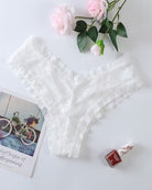 White lace mesh low-rise thong panties, flat lay with soft scalloped lace edges