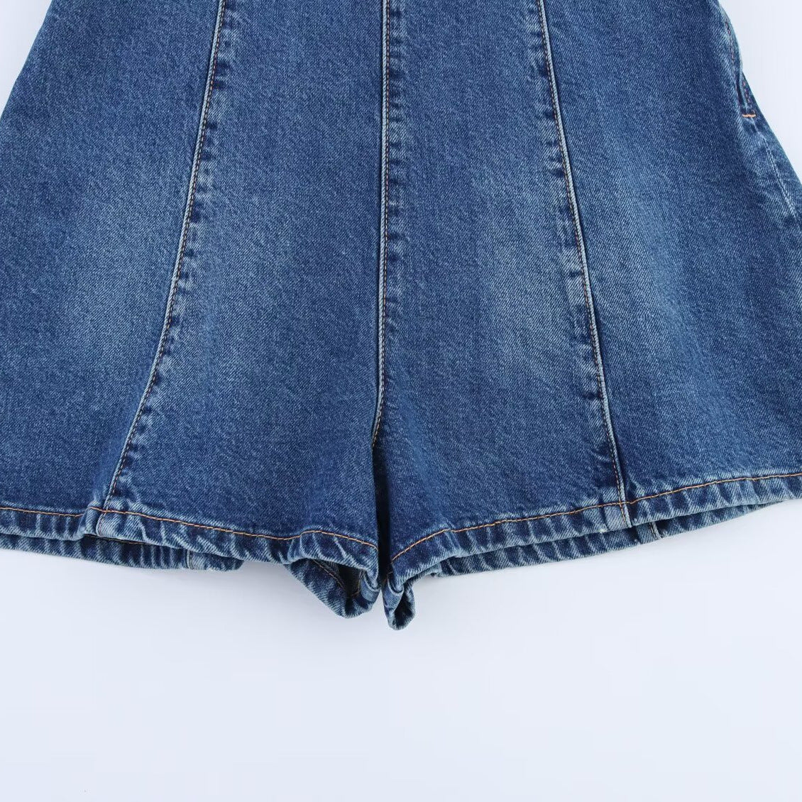 Blue denim halter romper with panel seams and cuffed shorts hem