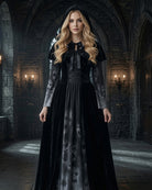 Black long sleeve maxi dress with skull-print panel, tie-neck bodice, attached cape